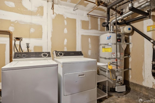 laundry room featuring laundry area, strapped water heater, and independent washer and dryer