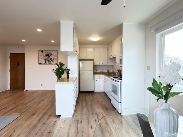 kitchen featuring sink, white appliances, light hardwood / wood-style flooring, ceiling fan, and white cabinets