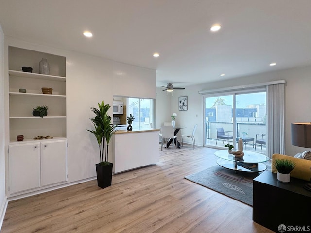 living room featuring ceiling fan and light wood-type flooring