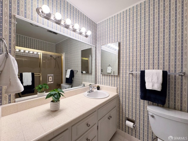 bathroom featuring crown molding, vanity, toilet, and walk in shower