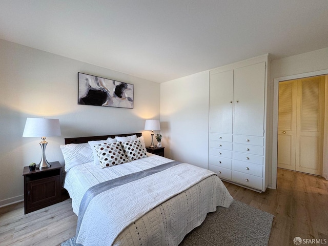 bedroom with light wood-type flooring and a closet