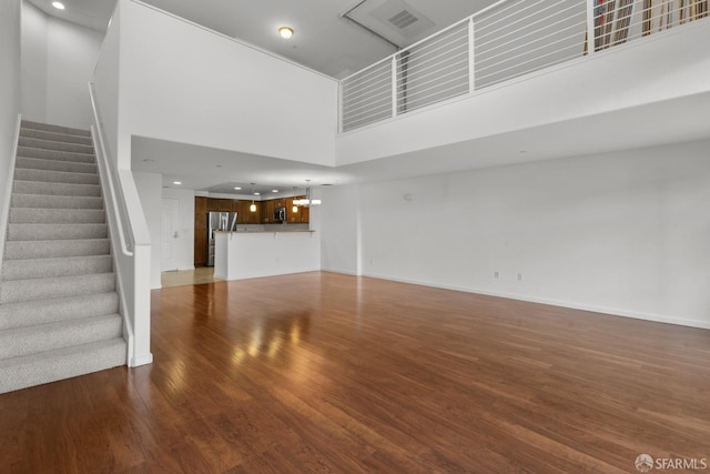 unfurnished living room featuring dark hardwood / wood-style flooring and a high ceiling