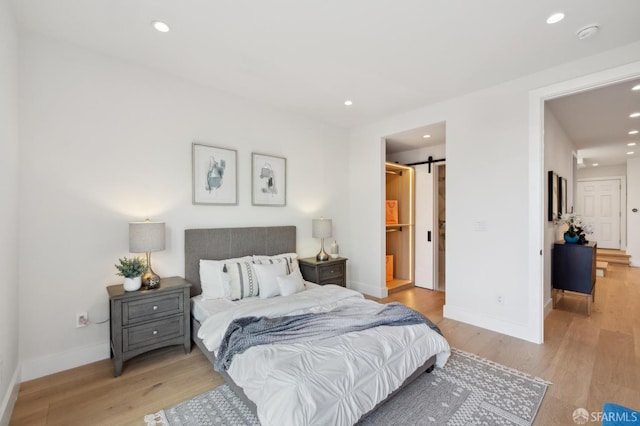 2287 45th Ave, San Francisco, CA 94116 - bedroom featuring baseboards, recessed lighting, light wood-style floors, a barn door, and ensuite bath