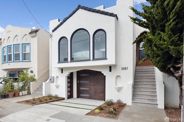 2287 45th Ave, San Francisco, CA 94116 - view of front of home featuring stairs, a garage, stucco siding, and driveway