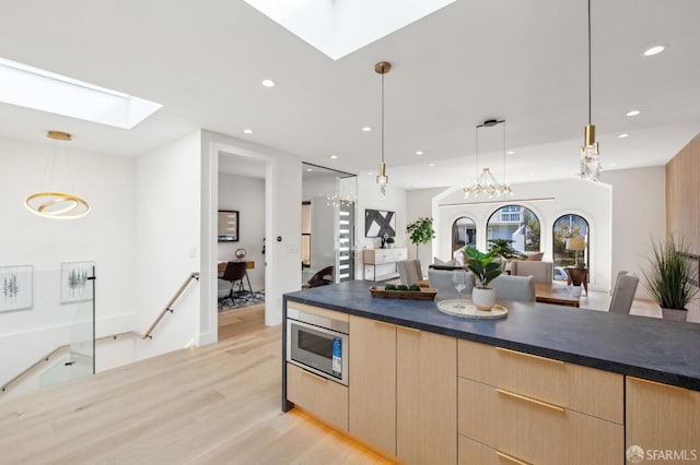 2287 45th Ave, San Francisco, CA 94116 - kitchen featuring a skylight, stainless steel microwave, light wood-style floors, light brown cabinets, and open floor plan