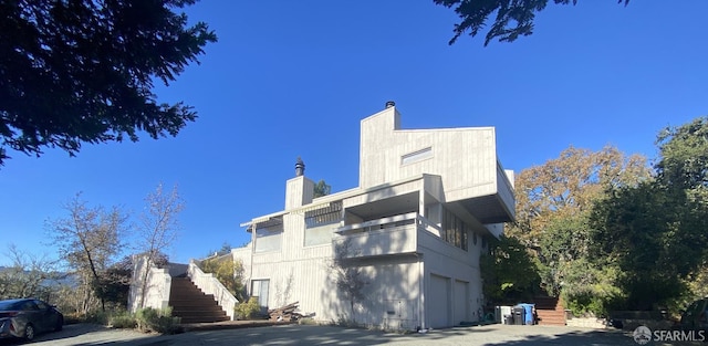 view of property exterior featuring stairway and an attached garage