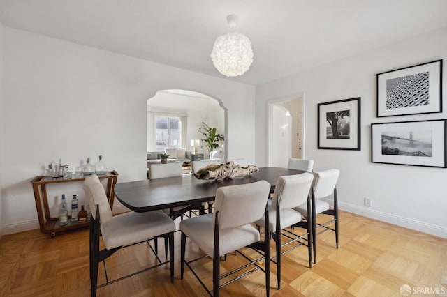 dining area with an inviting chandelier and light parquet floors