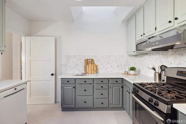 kitchen featuring stainless steel gas stove, gray cabinetry, and white dishwasher