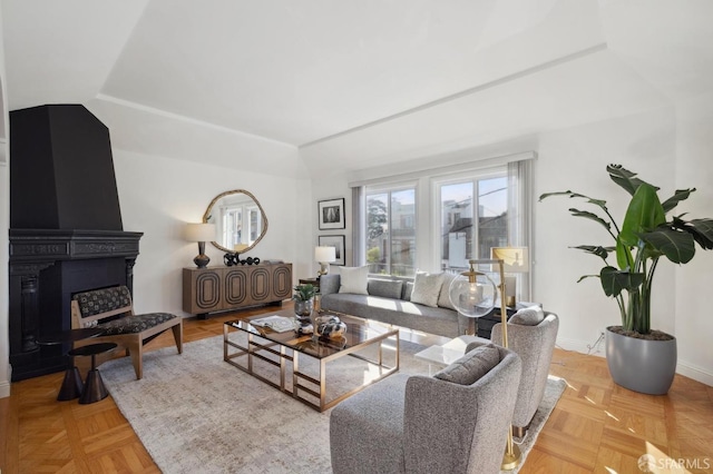 living room with a large fireplace and light parquet floors