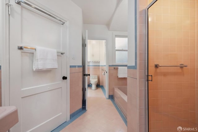 bathroom featuring toilet, tile walls, separate shower and tub, and tile patterned floors