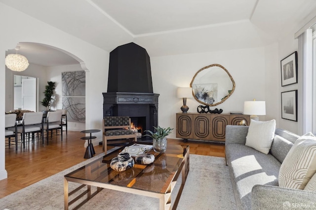 living room featuring parquet floors, a fireplace, and a tray ceiling