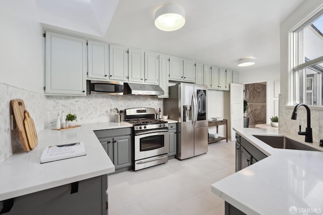 kitchen featuring tasteful backsplash, sink, gray cabinetry, and stainless steel appliances