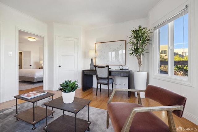 living room with ornamental molding, a healthy amount of sunlight, and hardwood / wood-style floors