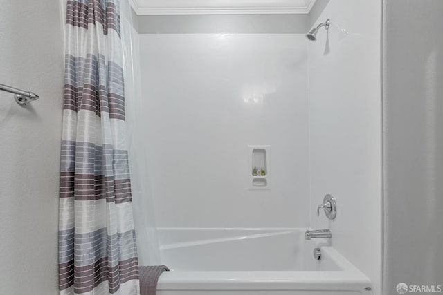 bathroom with ornamental molding and shower / bath combo