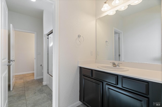 bathroom featuring baseboards, tub / shower combination, and vanity
