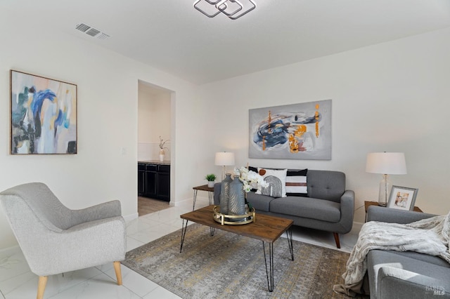 living room with baseboards, visible vents, and marble finish floor