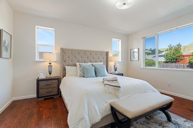 bedroom with baseboards and dark wood-type flooring