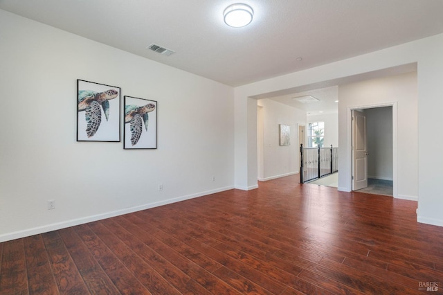 unfurnished room featuring visible vents, baseboards, and wood finished floors