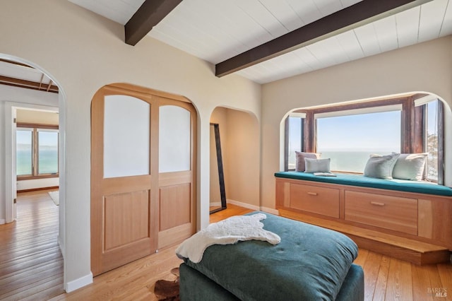 272 Ocean Pkwy, Bolinas, CA 94924 - bedroom with arched walkways, beam ceiling, multiple windows, and light wood-style flooring