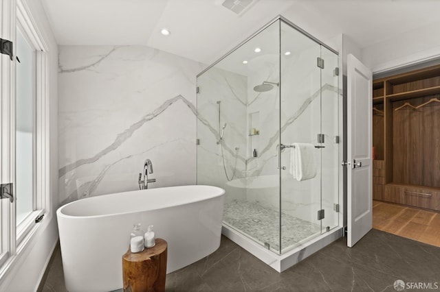 bathroom with lofted ceiling, hardwood / wood-style floors, and plus walk in shower