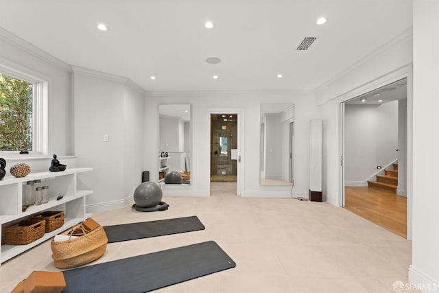 exercise area with light hardwood / wood-style floors and ornamental molding