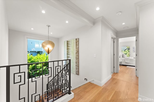 corridor featuring beamed ceiling, ornamental molding, and light hardwood / wood-style flooring