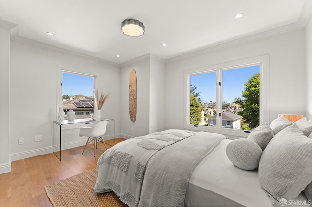 bedroom featuring multiple windows, crown molding, and light hardwood / wood-style flooring