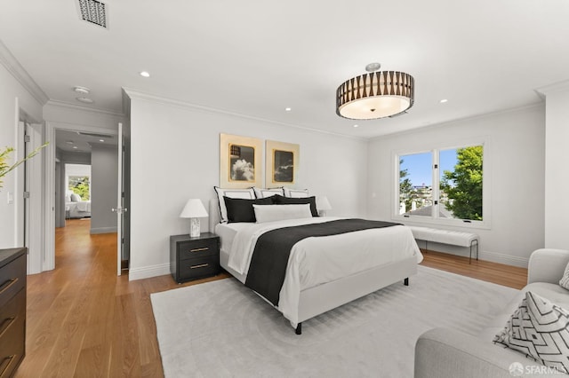 bedroom featuring light hardwood / wood-style flooring and ornamental molding