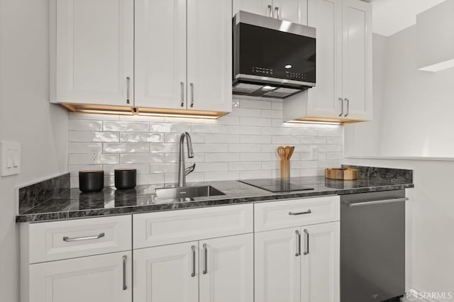 kitchen featuring dark stone counters, sink, white cabinetry, backsplash, and appliances with stainless steel finishes