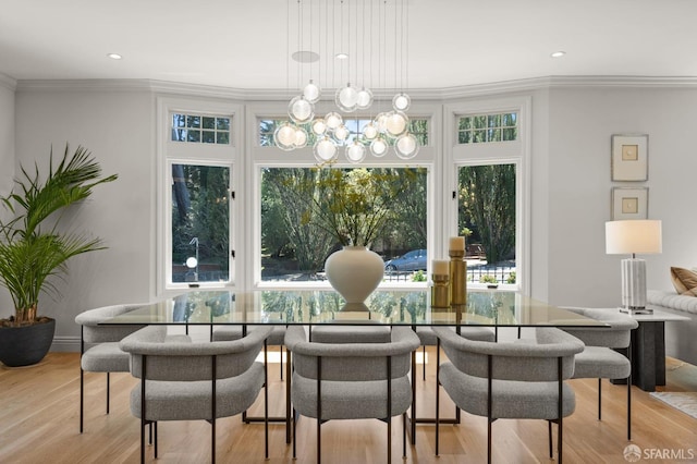 dining room with ornamental molding, light hardwood / wood-style flooring, and a chandelier