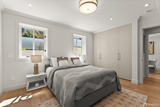 bedroom featuring crown molding and light hardwood / wood-style flooring