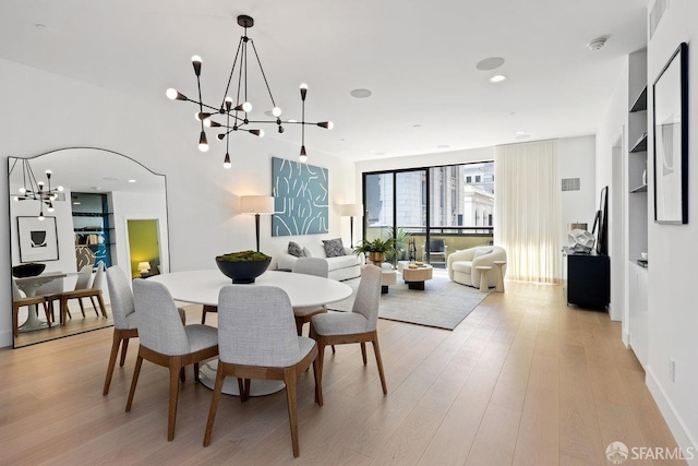 dining area featuring light hardwood / wood-style floors and a chandelier