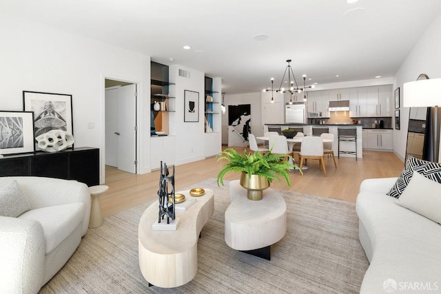 living room featuring light hardwood / wood-style flooring and a notable chandelier