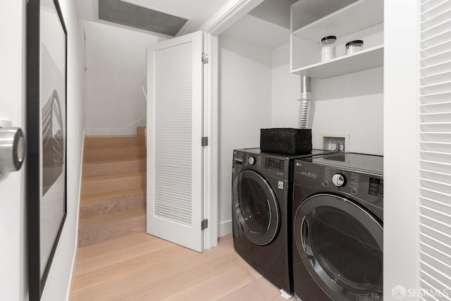 washroom with light hardwood / wood-style flooring and washing machine and clothes dryer