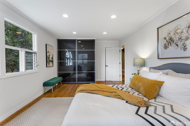 bedroom featuring crown molding and wood-type flooring