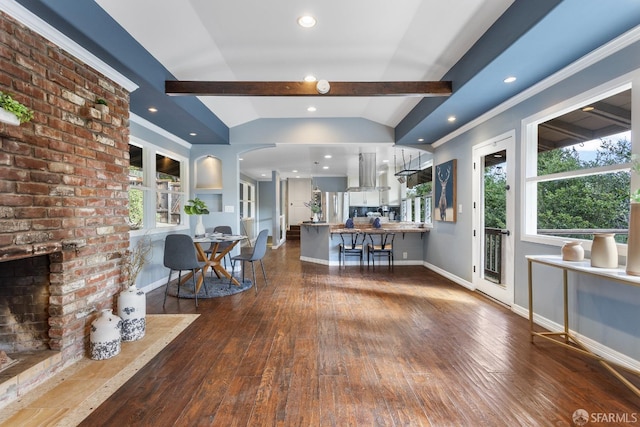 unfurnished living room with lofted ceiling with beams, a brick fireplace, and dark hardwood / wood-style flooring