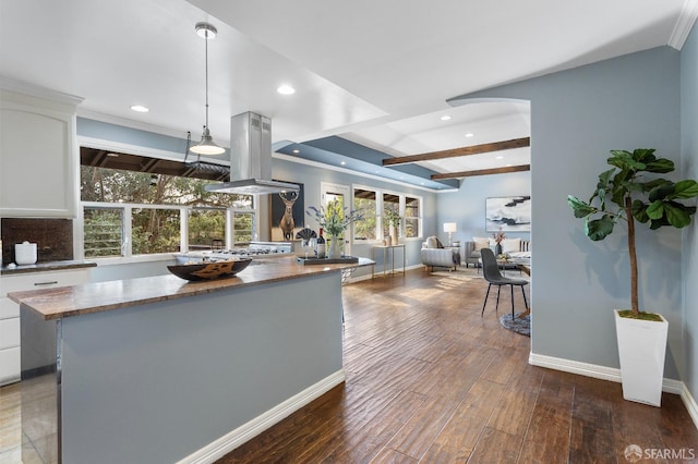 kitchen featuring dark wood-type flooring, a kitchen island, pendant lighting, island exhaust hood, and white cabinets