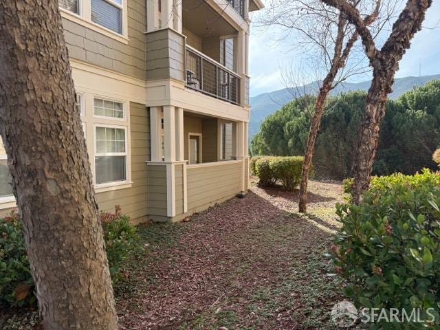 view of property exterior featuring a balcony and a mountain view