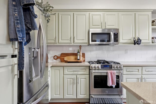 kitchen with tasteful backsplash, stainless steel appliances, and cream cabinetry