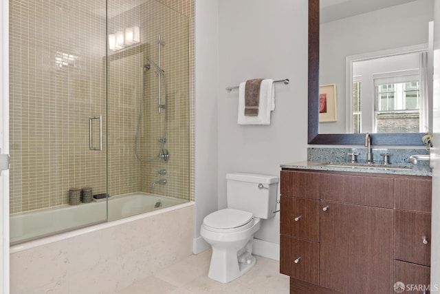 full bathroom with tile patterned floors, bath / shower combo with glass door, vanity, and toilet