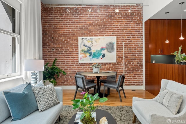 living room with light hardwood / wood-style flooring and brick wall