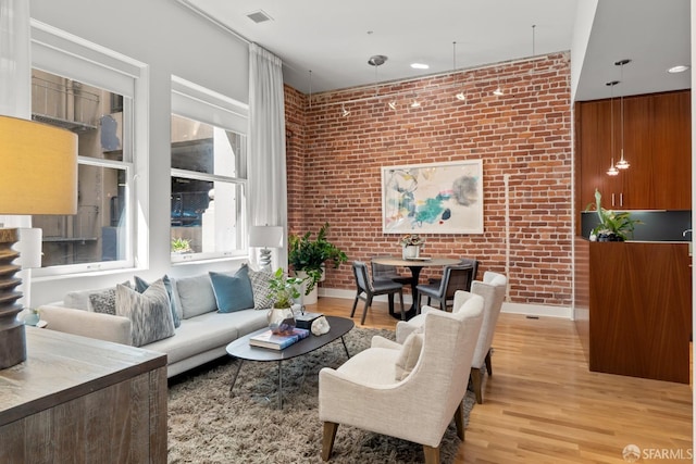 living room featuring light hardwood / wood-style floors and brick wall