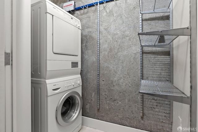 clothes washing area featuring stacked washer / drying machine