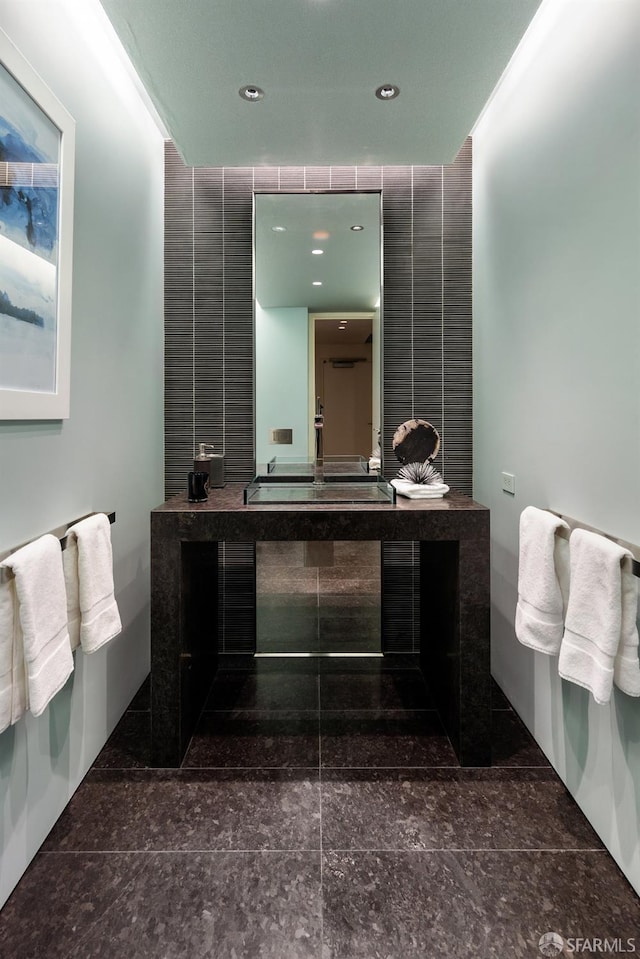 bathroom with vanity and tile walls