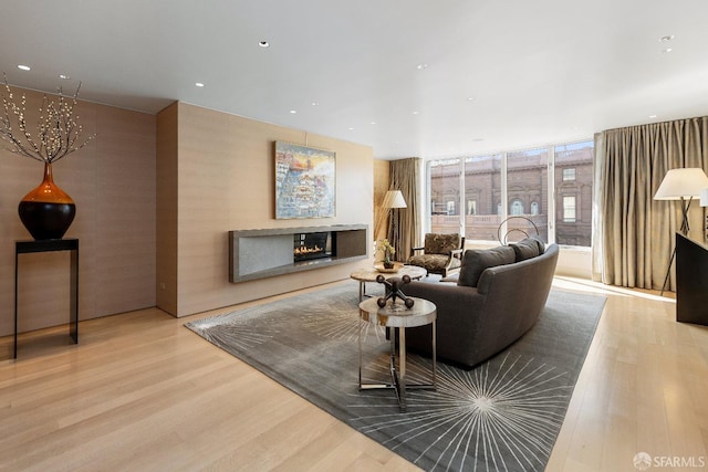 living room featuring a wall of windows and light wood-type flooring