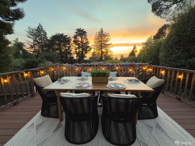 deck at dusk featuring outdoor dining area