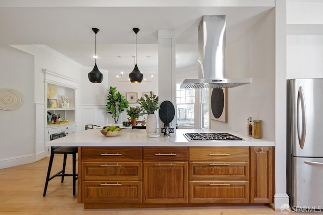 2864 Sacramento St, San Francisco, CA 94115 - kitchen featuring appliances with stainless steel finishes, island exhaust hood, light countertops, light wood-style floors, and brown cabinets