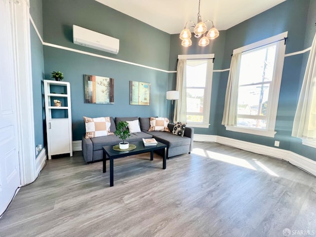 living room featuring a wall mounted AC, hardwood / wood-style flooring, and a chandelier