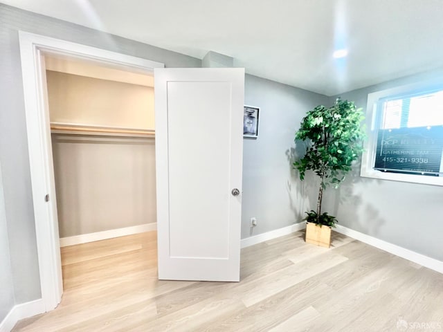 unfurnished bedroom with a closet and light wood-type flooring