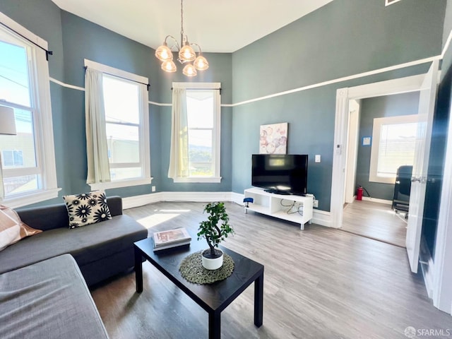 living room featuring a wealth of natural light, a chandelier, and hardwood / wood-style flooring